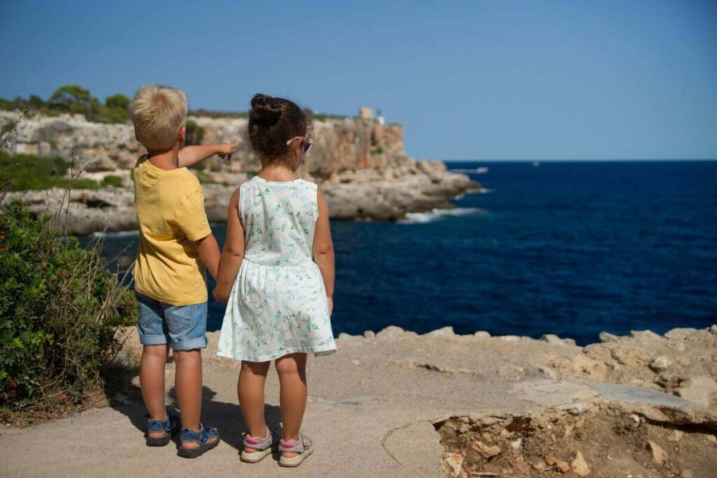 海を見つめる男の子と女の子の後ろ姿